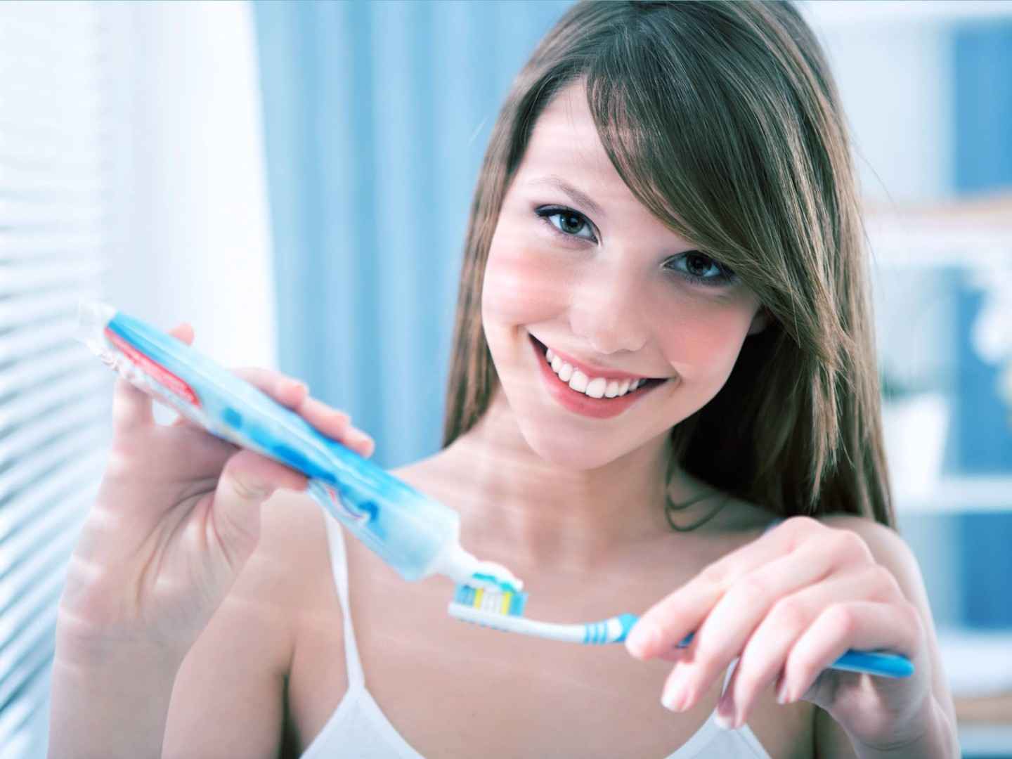 Junge Frau, die sich die Zähne putzt.