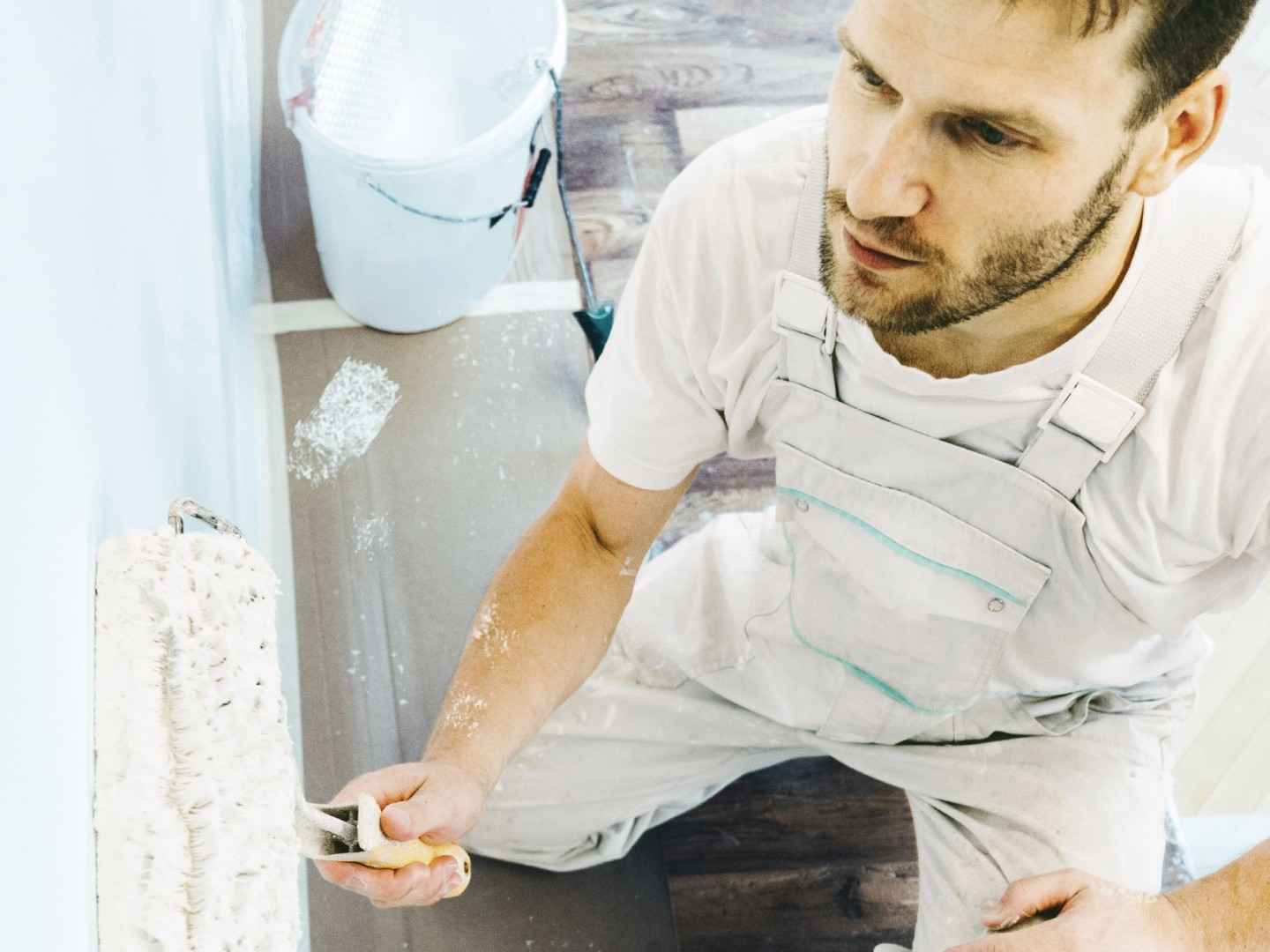 Ein Maler streicht eine Wand