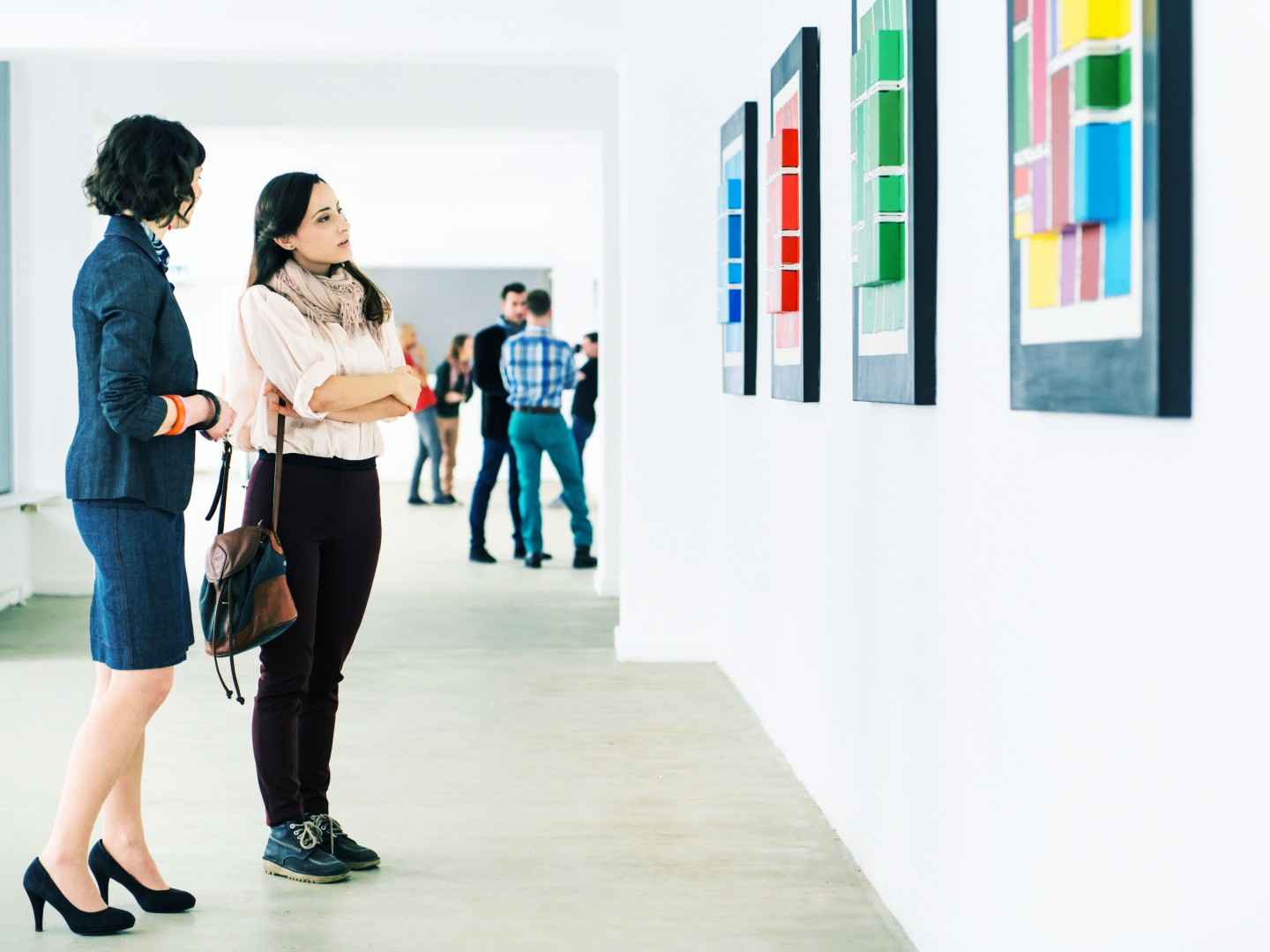 Gothaer Kunstausstellungsversicherung: Besucher*innen bewundern moderne Kunst auf einer Kunstausstellung.