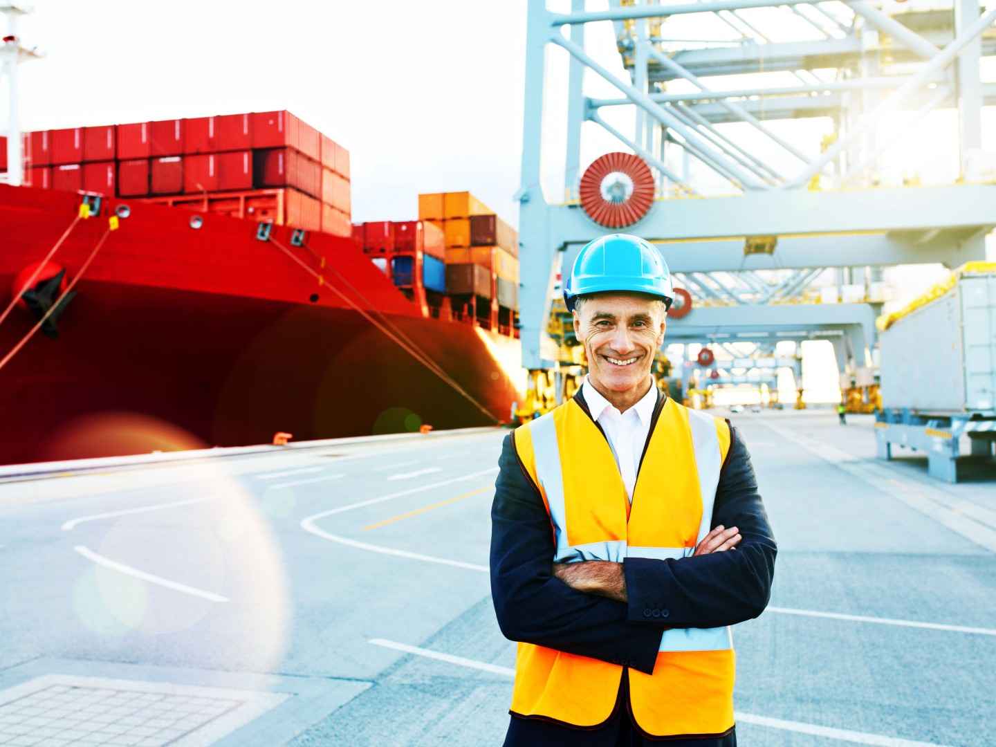 Gothaer Warentransportversicherung: Verantwortlicher Leiter vor Container-Schiff kümmert sich um den Transport.
