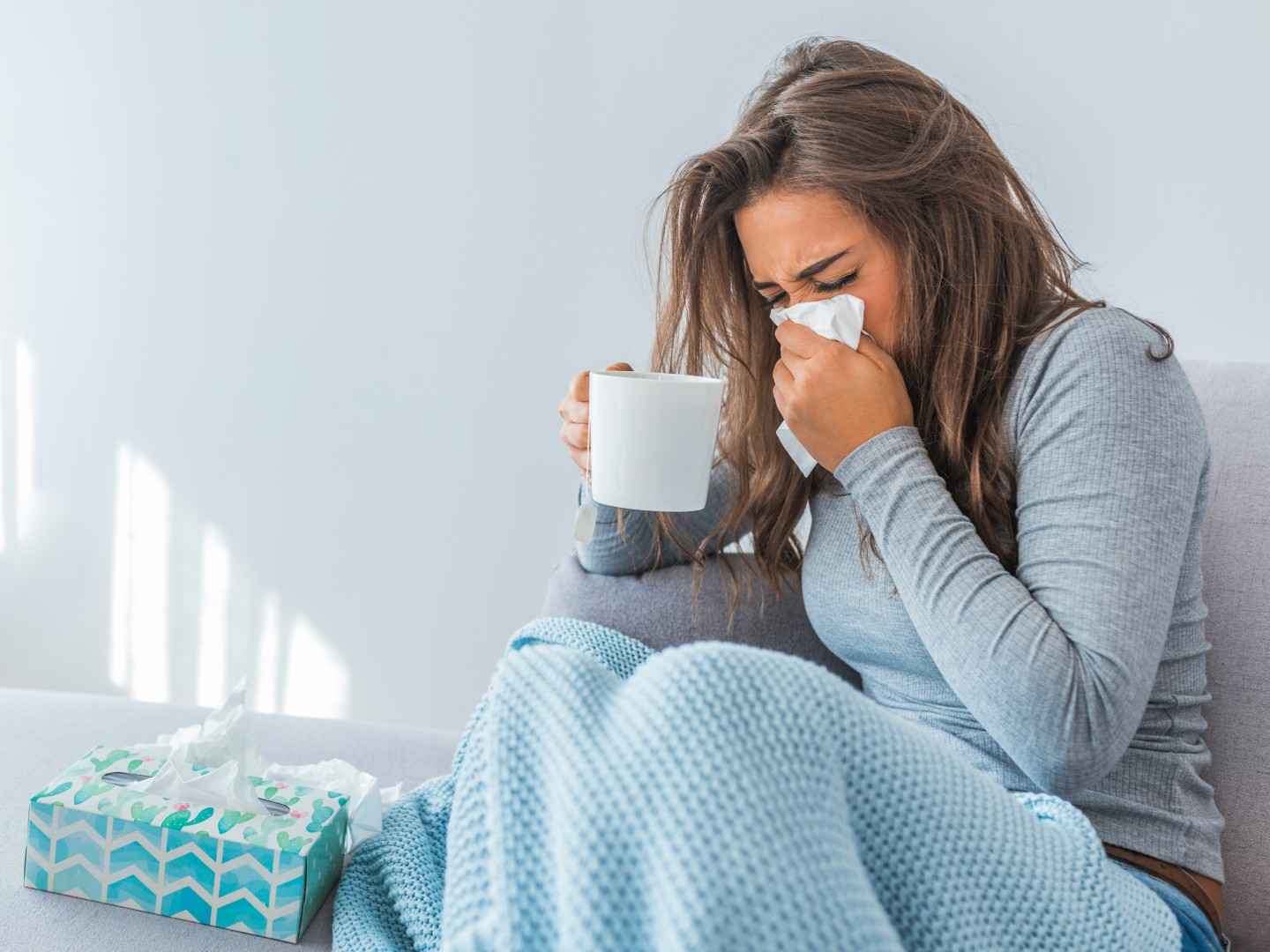 Junge Frau ist erkältet und will sich krankmelden.