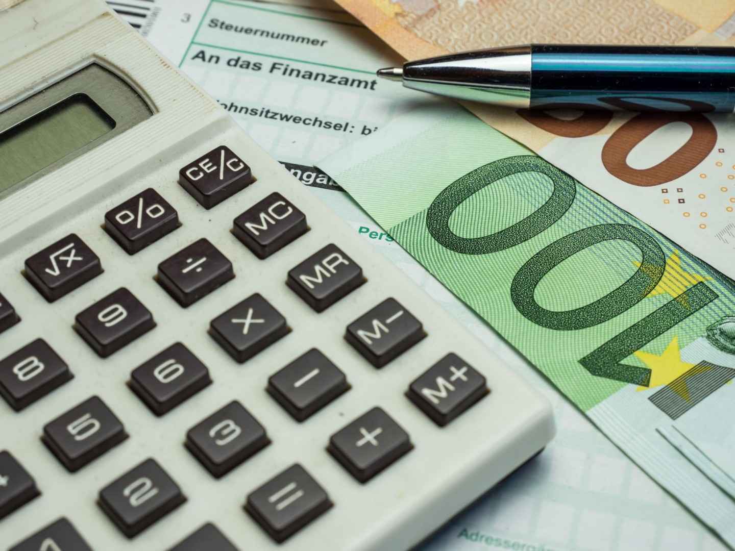 Gothaer Online-Services rund um Nachweise/Bescheinigungen: Taschenrechner, Geldscheine und ein Stift liegen auf einer Steuererklärung an das Finanzamt