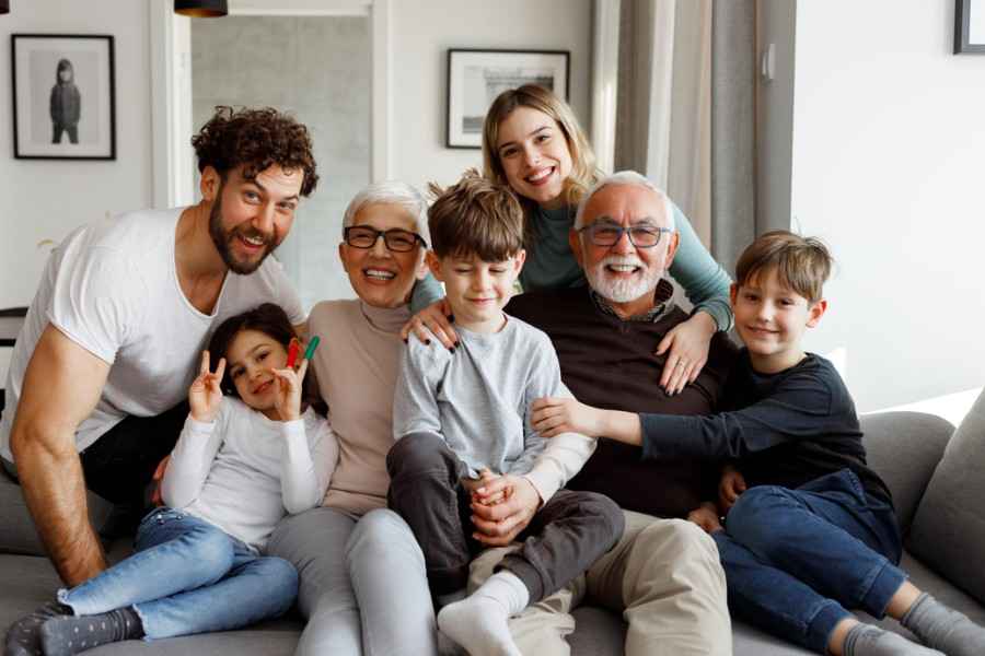 Eine glückliche große Familie sitzt auf der Couch im Wohnzimmer.