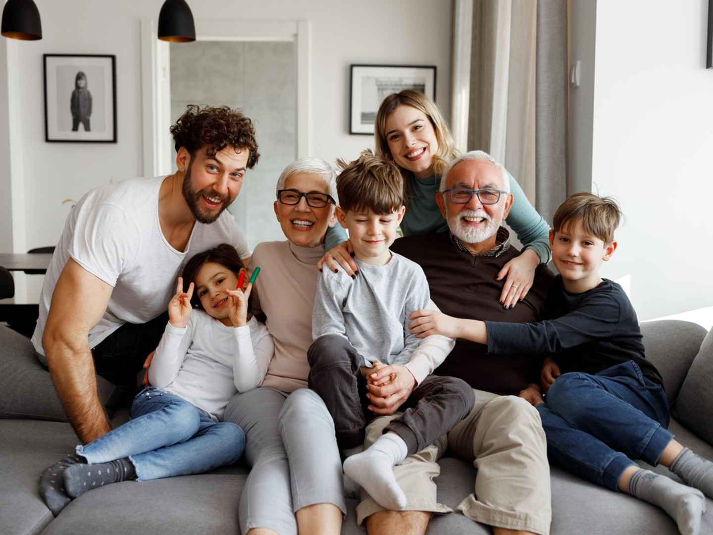 Eine glückliche große Familie sitzt auf der Couch im Wohnzimmer.