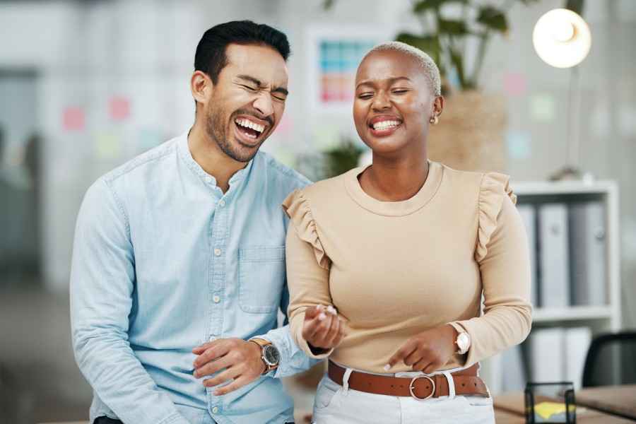 Zwei internationale Fachkräfte lachen miteinander im Büro