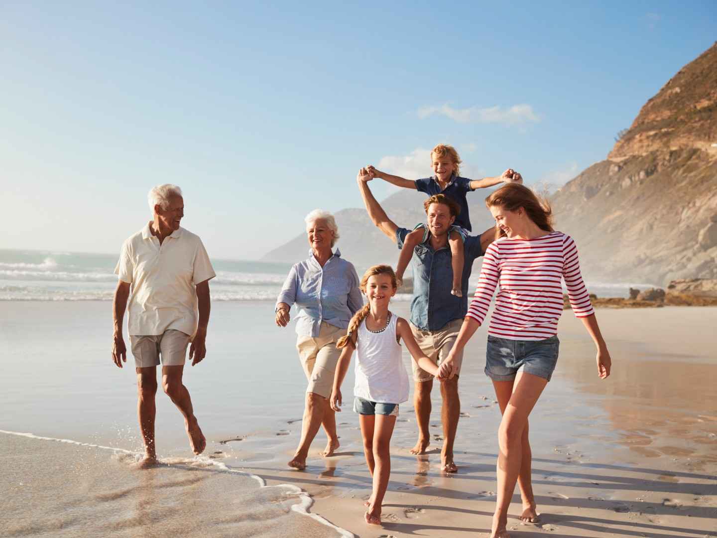 Vierköpfige Familie mit Oma und Opa am Meer