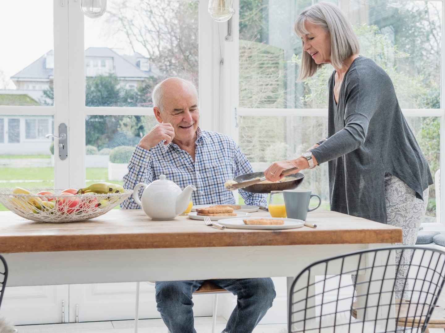 Gothaer Glasversicherung: Älteres Ehepaar frühstückt im Wintergarten.