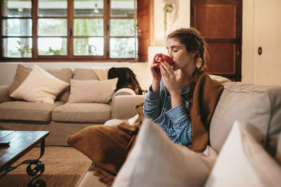 Gothaer Haus- und Wohnungsschutzbrief: Dank dieser Versicherung - diesem Schutzbrief - kann die Frau auf dem Sofa ganz beruhigt einen Tee trinken.