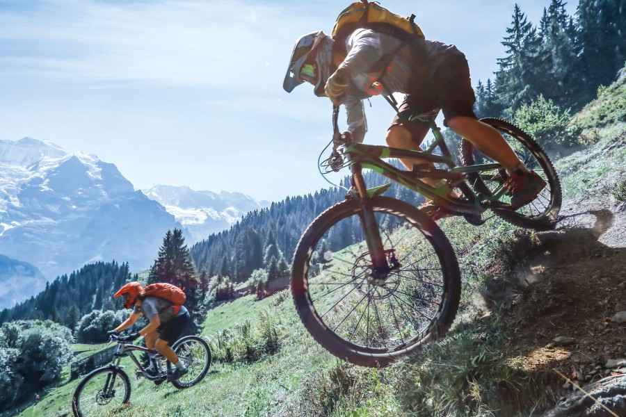 Gothaer Unfallversicherung: Mountainbiker fahren einen steilen Hang hinunter