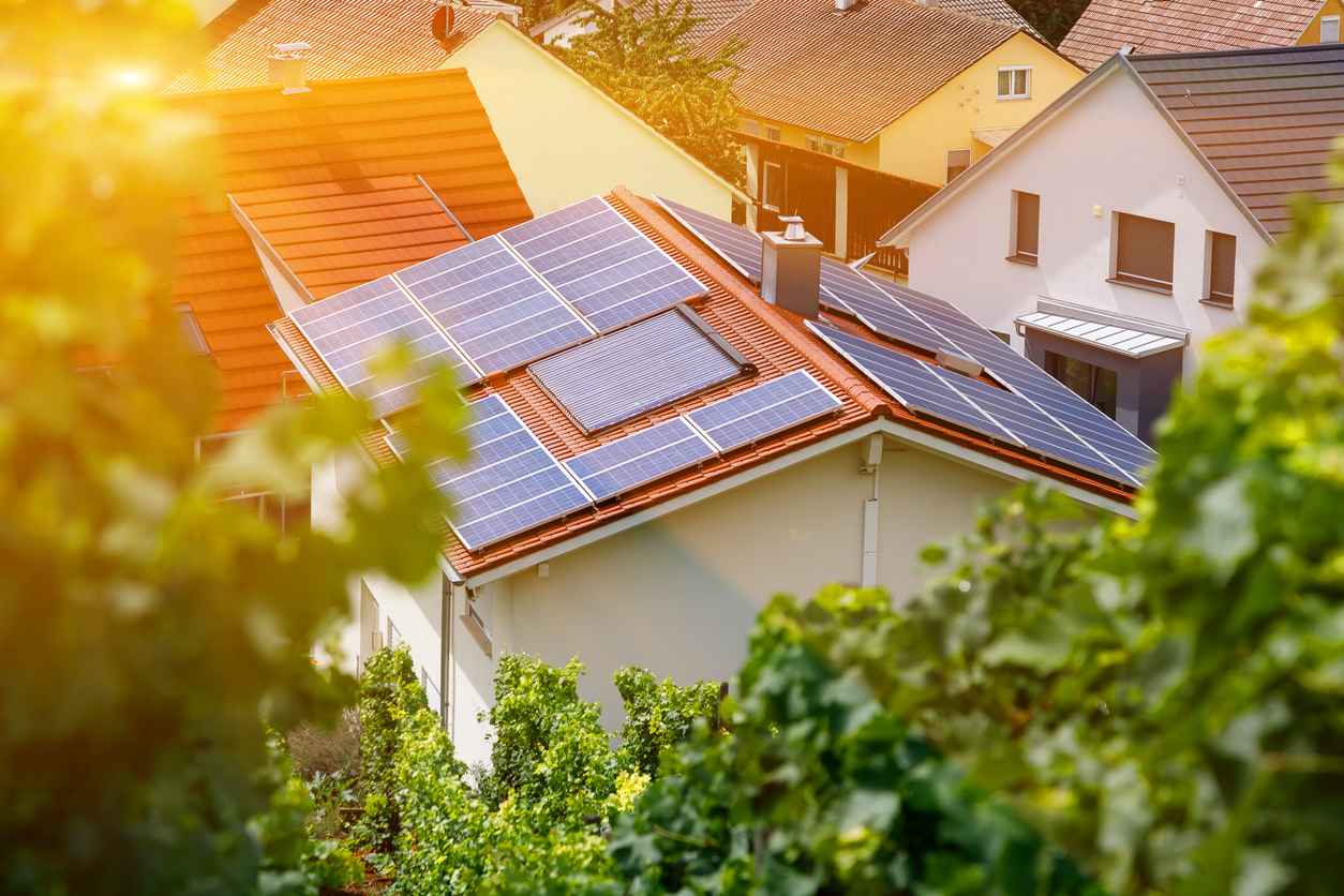 Sonne scheint auf eine Photovoltaik-Anlage auf dem Dach eines Hauses.