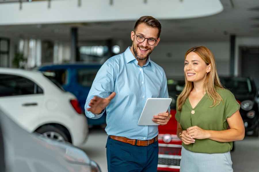 Gothaer Ratgeber Auto Leasing: Ein Mann führt ein Beratungsgespräch mit einer Frau in einem Autohaus.