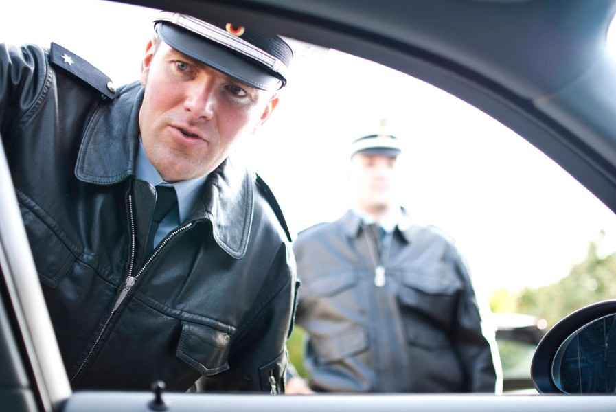 Fahren ohne Versicherungsschutz. Polizist steht am Autofenster.